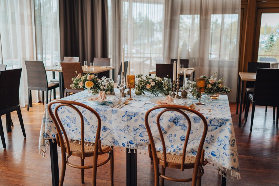 Svatební stůl s výrazným modro bílým ubrusem.
