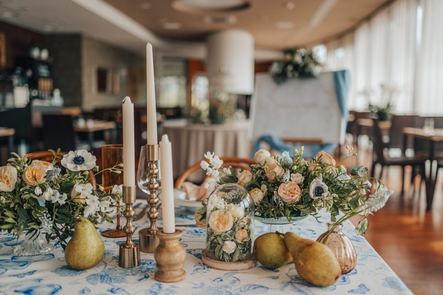 Svatební květiny a svíčky na nazdobeném stole.