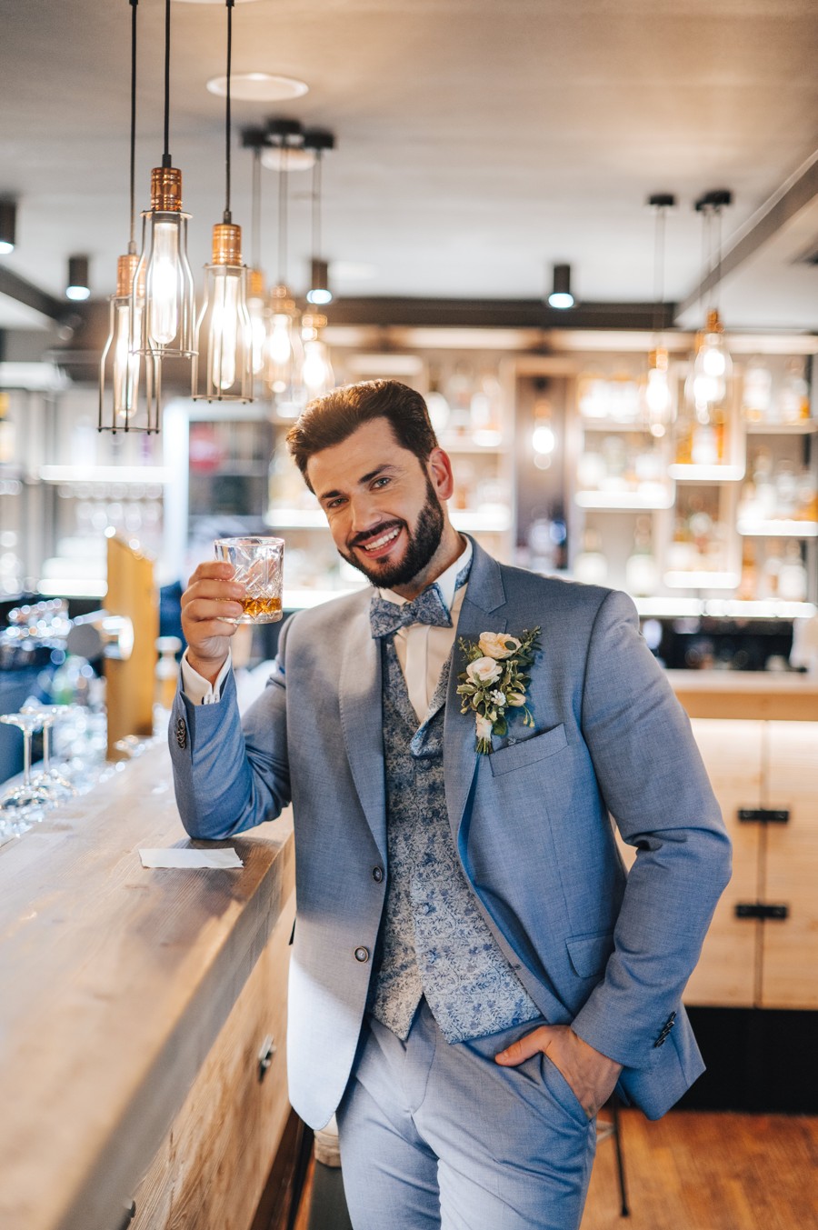 Portrét ženicha v hotelovém baru se skleničkou whiskey.